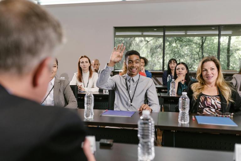 a young man raising his hand at a business conference